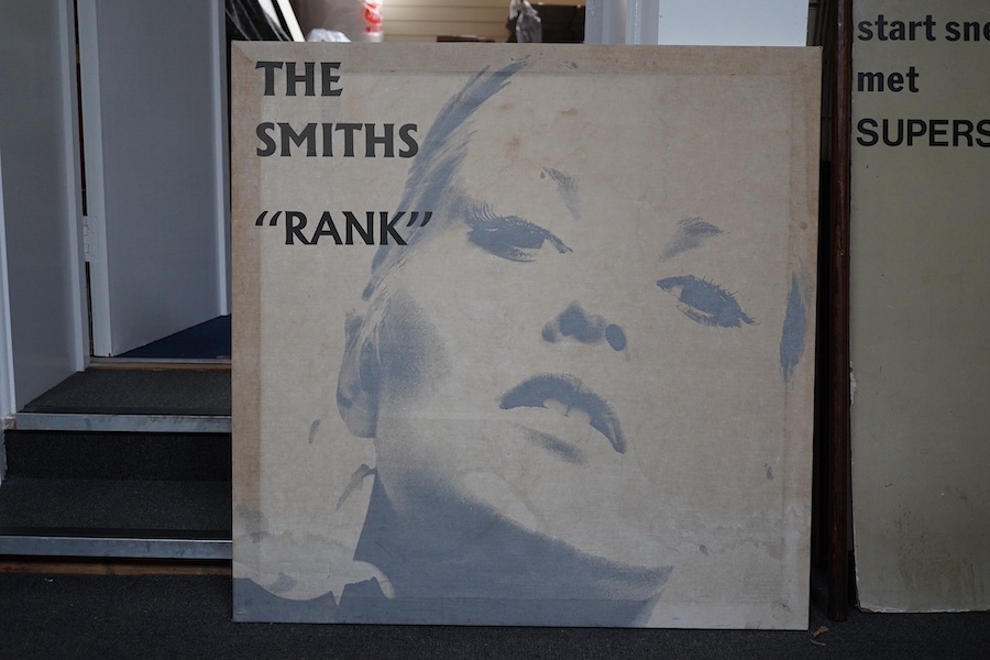 The Smiths interest; a 1980s printed cloth advertising banner mounted on wood stretchers, promoting the live album ‘Rank’, and featuring a close up portrait of Alexandra Bastedo. Condition fair, some staining.